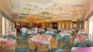 une salle de banquet avec des tables et des chaises roses dans l'établissement Neemrana Fort-Palace, à Neemrana
