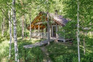 a log cabin in the woods with trees at Lehmiranta in Tammijärvi
