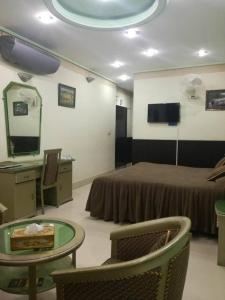 a hotel room with a bed and a table and a mirror at Hotel City View Peshawar in Peshawar +15 photos