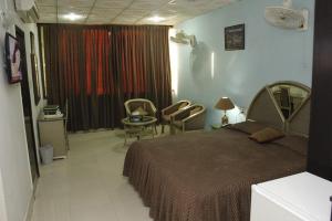 a bedroom with a bed and a table and chairs at Hotel City View Peshawar in Peshawar