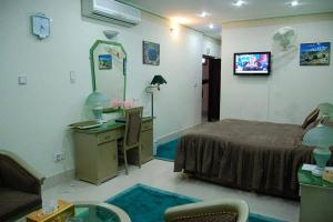 a room with a bed and a desk with a computer at Hotel City View Peshawar in Peshawar