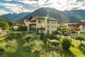 a building in a village with mountains in the background at Residence Ortlerhof in Prato allo Stelvio