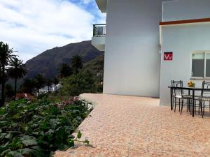 a patio with a table and chairs and a mountain at Vivienda Casa Mary in Valle Gran Rey