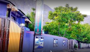 Un tren azul está estacionado junto a un edificio en Naveed Tourist Inn, en Gilgit