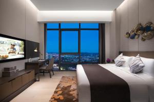 מיטה או מיטות בחדר ב-Ascott Songshan Lake Dongguan