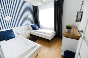 mały pokój z łóżkiem i kanapą w obiekcie Słoneczne Tarasy II - M & K Apartamenty Złota Wydma w Gdańsku
