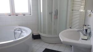 łazienka z wanną, umywalką i prysznicem w obiekcie Apartment Leśniczówka w Radomiu +3 zdjęcia