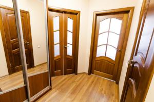 a hallway with wooden doors and a mirror at Центр! Папанинцев 111-53 in Barnaul