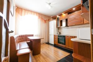 a kitchen with wooden cabinets and a table in a room at Центр! Папанинцев 111-53 in Barnaul
