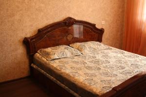 1 cama con cabecero de madera en un dormitorio en 1-комнатная квартира на набережной, en Pavlodar