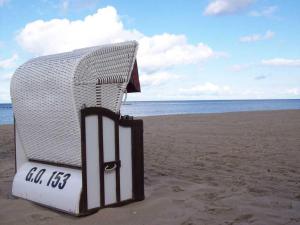 einen weißen Stuhl am Strand in der Unterkunft Ferienwohnung am Waldesrand in Ostseebad Sellin