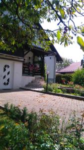a house with a brick driveway in front of a building at Apartman Sunce in Ogulin