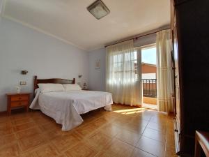 a bedroom with a bed and a large window at Hostal Arli in San Francisco