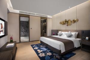 a bedroom with a large bed and a television at Ascott Songshan Lake Dongguan in Dongguan +34 photos