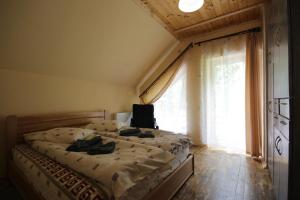 una camera da letto con un letto e una grande finestra di Guest house Alyaska a Bukovel