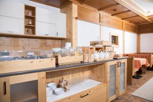 una cocina con armarios de madera y una barra con jarrones en Pension Rofan en Reith im Alpbachtal