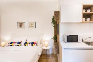 biała sypialnia z łóżkiem i kuchnią w obiekcie Studio Apartments near park Zrinjevac w Zagrzebiu