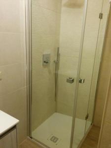 La salle de bains est pourvue d'une douche avec une porte en verre. dans l'établissement Honey House Parma, à Parme