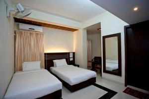 巴纳内拉斯圣门酒店的有两张床和一面镜子的酒店房间