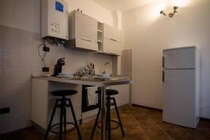 eine kleine Küche mit zwei Barhockern und einem Kühlschrank in der Unterkunft Piccola casa vacanze - Small vacation house in Porto Valtravaglia