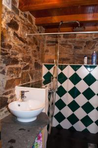 La salle de bains est pourvue d'un lavabo et d'un mur en damier. dans l'établissement Azoka by the River- Proença-a-Nova, à Maljoga de Proença