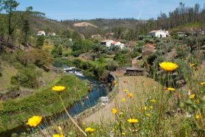 een uitzicht op een rivier met gele bloemen op een heuvel bij Azoka by the River- Proença-a-Nova in Maljoga de Proença