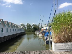 eine Gruppe von Booten wird in einem Kanal angedockt in der Unterkunft Bootshaus am See in Neusiedl am See