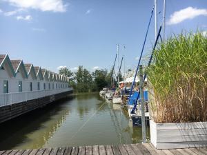 a group of boats are docked in a canal at Bootshaus am See in Neusiedl am See