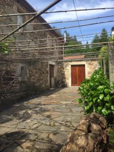 a stone building with a wooden door and a yard at Casa Labazá in Villarmayor