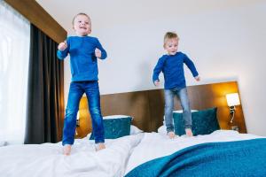 two young boys jumping on top of a bed at Hotel Raumanlinna in Rauma