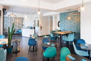 a restaurant with blue chairs and tables in a room at Hôtel Relais Acropolis in Nice