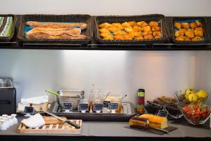a table with several trays of food on a shelf at Hôtel Relais Acropolis Nice in Nice +42 photos