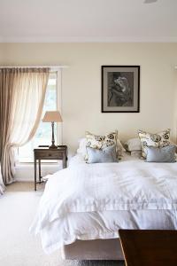 a white bedroom with a bed and a window at Rosby Guesthouse and Studio in Eurunderee