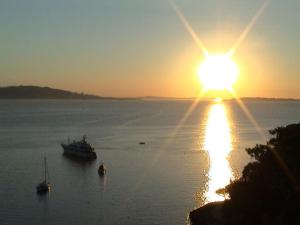 Sonnenuntergang über einem großen Wasserkörper mit Booten in der Unterkunft VILLAS and SUITES LA CORAILLERE RESORT in Théoule-sur-Mer