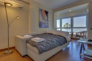 a bedroom with a bed and a table and windows at HORIZONTE Sunny Home by Cadiz4Rentals in Cádiz
