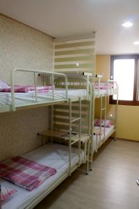 Zimmer mit 3 Etagenbetten und einem Fenster in der Unterkunft Nearest Guesthouse in Jeonju