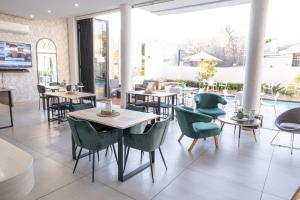 ein Restaurant mit Tischen und Stühlen und einem Pool in der Unterkunft One Hyde Park - Sandton in Johannesburg