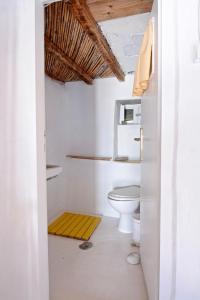 ein Badezimmer mit einem WC und einer gelben Matte in der Unterkunft Villa Clio Serifos in Serifos Chora