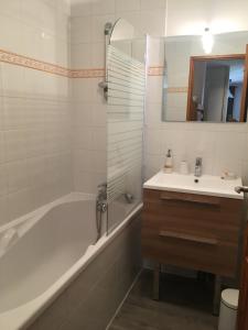 a bathroom with a tub and a sink at Les Balcons de Vaujany in Vaujany +22 photos