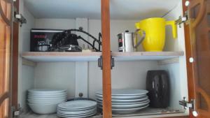 a pantry with plates and dishes on shelves at Sudarshi's Home in Mount Lavinia