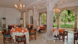 Neemrana's - Deo Bagh في قاليور: مطعم فيه طاولات وكراسي في الغرفة