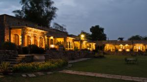 um edifício iluminado à noite com luzes em Neemrana's - Deo Bagh em Gwalior