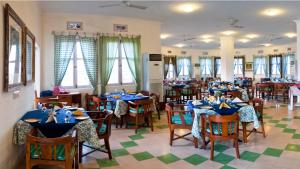 a dining room filled with tables and chairs with blue table settings at Neemrana's - Hill Fort - Kesroli in Alwar