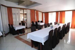 a conference room with white tables and black chairs at Hotel Orion in Ivanec