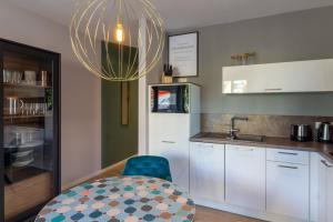 a kitchen with a blue chair and a chandelier at Baabe Villen Ensemble FeWo 44 Cozy in Baabe