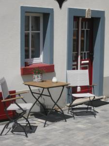 a table and chairs in front of a building at Hossies Hof - Luxus Ferienwohnung Alter Stall in Bertsdorf