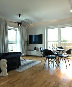 salon z kanapą, stołem i krzesłami w obiekcie Blue Velvet Premium Apartments II w Toruniu