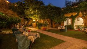 eine Terrasse mit Tischen und Stühlen in einem Garten in der Nacht in der Unterkunft Neemrana's - Hill Fort - Kesroli in Alwar