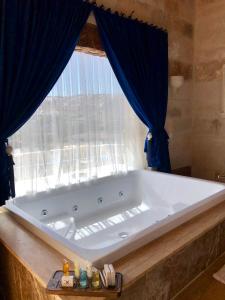 a large bath tub in a bathroom with a window at Doors Of Cappadocia Hotel in Göreme
