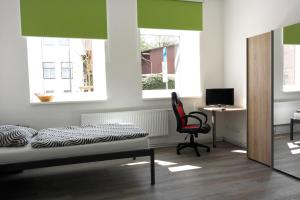a bedroom with a bed and a desk and a chair at Alte Post Gäste- und Monteurzimmer in Horneburg